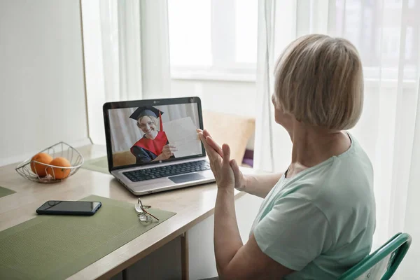 Virtual graduation ceremony. Senior woman congratulating daughter during online video call — Stock Photo, Image