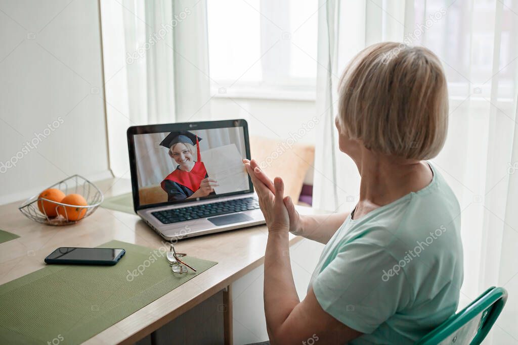 Virtual graduation ceremony. Senior woman congratulating daughter during online video call