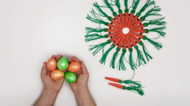 Düz, doğal boyalı yumurtaları ve ahşap tokalı havuç çelenklerini gösteriyor.