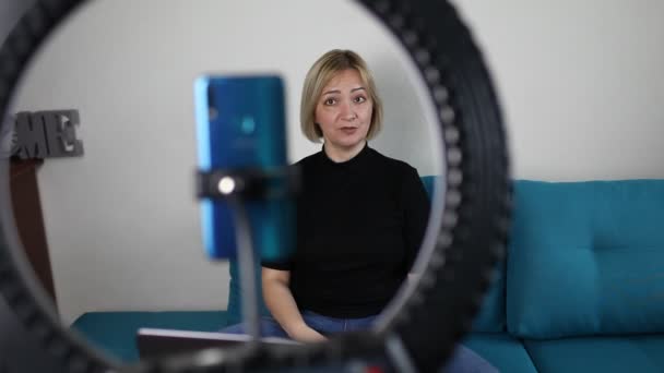 Donna che parla con la fotocamera e registra video con smartphone e lampada ad anello a casa, vlogger — Video Stock