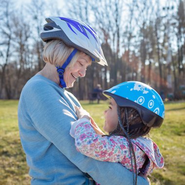 Büyükannesiyle birlikte parkta paten kayan bir kız. Kucaklaşma ve destek.