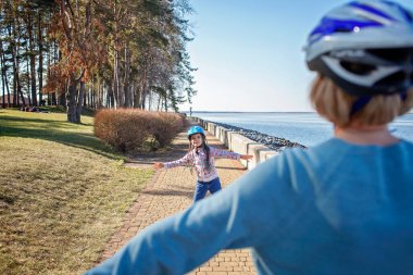 Kız, büyükannesiyle birlikte parkta paten kayıyor. Baharda açık havada.