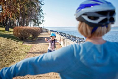 Kız, büyükannesiyle birlikte parkta paten kayıyor. Baharda açık havada.