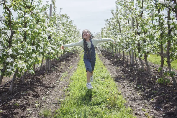 Preteen girl enjoying blooming apple garden in spring, relax and freedom, beauty of nature — Stock Photo, Image