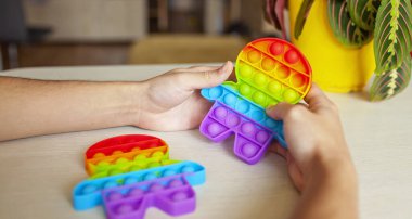 Stres, sakinlik ve uyum ve zihinsel sağlık kavramını rahatlatmak için hareketli duyusal oyuncaklarla oynayan genç bir adam.