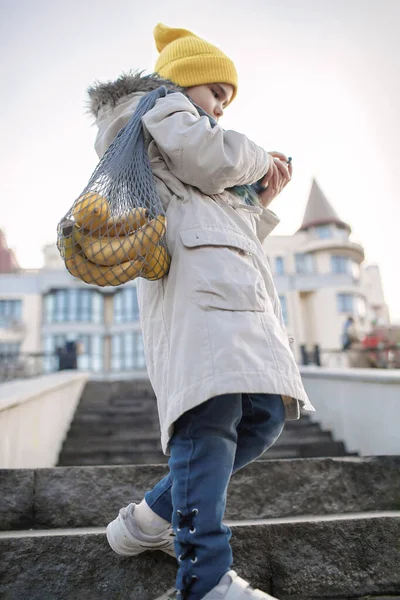 Ragazza preadolescente seduta sulle scale di strada e sms con smartphone sulla strada dallo shopping — Foto Stock
