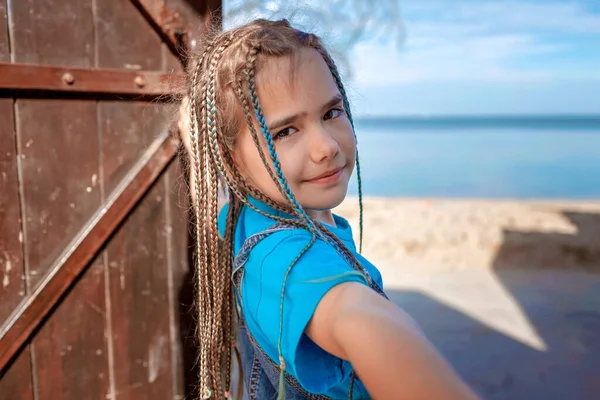 Preteen happy girl opening wooden door to sunny seaside, follow me shot, hello summer concept — Stock Photo, Image