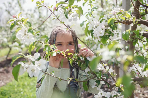 Kaméleon lány élvezi virágzó almakert tavasszal, pihenés és szabadság, a természet szépsége — Stock Fotó