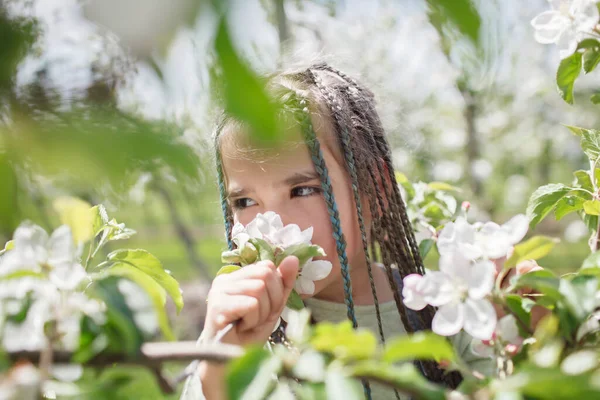 Девочка-подросток наслаждается цветущим яблоневым садом весной, релаксацией и свободой, красотой природы — стоковое фото
