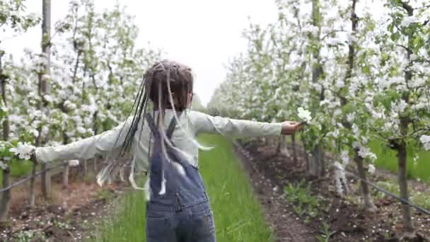 Menina adolescente desfrutando florescendo jardim de maçã na primavera, relaxar e liberdade, beleza da natureza — Vídeo de Stock