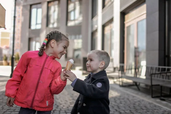 Menina doce engraçado desfrutar de sobremesa doce e compartilhá-lo com seu irmão, comida de rua, estilo de vida fora — Fotografia de Stock