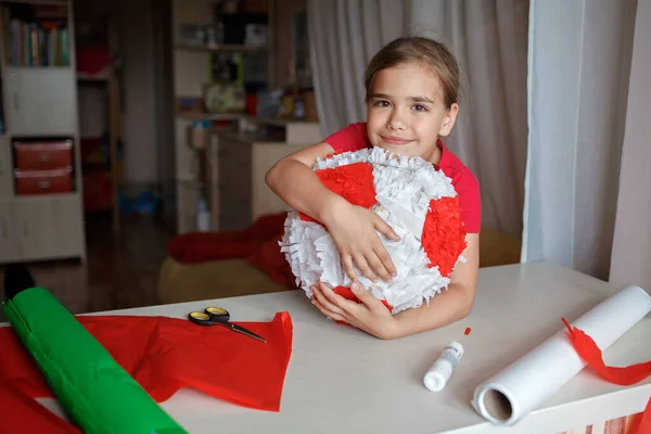 사용 한 상자와 컬러 종이로 만든 마분지로 피냐 타를 하고 있는 아이, 생일 파티에서 베이지 장식을 하는 아이 — 스톡 사진