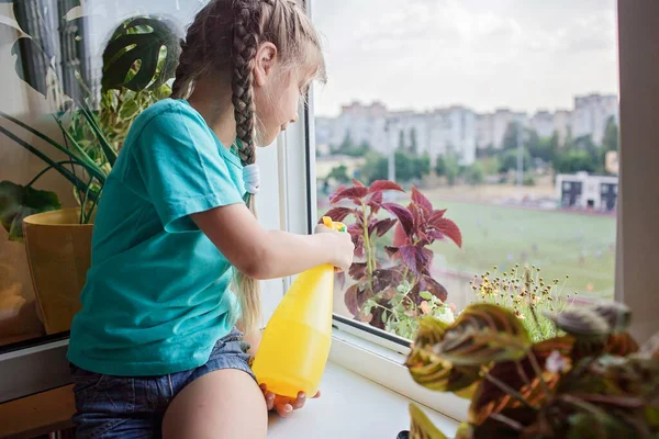 발코니에 있는 화초 관리를 도와 주는 귀여운 소녀, 식물 부모 컨셉 — 스톡 사진