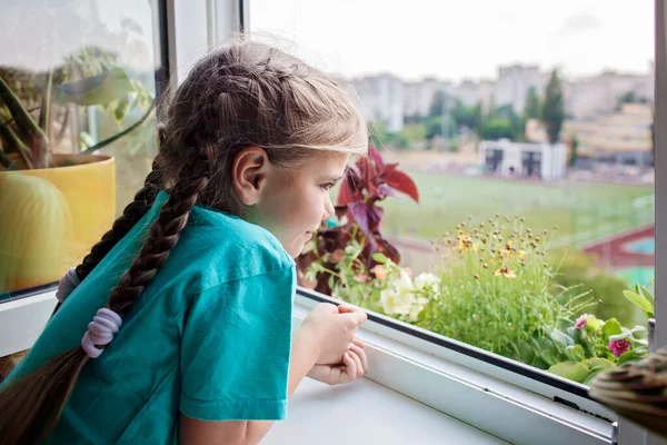 Χαριτωμένο κορίτσι που βοηθά στη φροντίδα για τα φυτά στο παράθυρο του μπαλκονιού, ιδέα των γονέων των φυτών — Φωτογραφία Αρχείου
