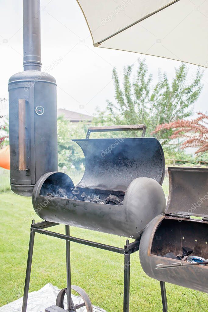 Smoker grill in home backyard, family patio, outdoor bbq party on open air, green garden background