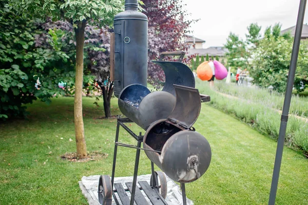 Гриль для курящих на заднем дворе, семейный патио, барбекю на открытом воздухе, зеленый сад Стоковая Картинка