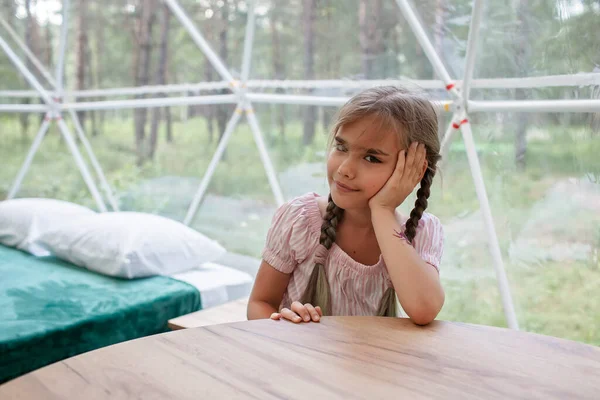 Girl looks over transparent bell tent in forest, glamping, luxury travel, glamourous camping — Stock Photo, Image