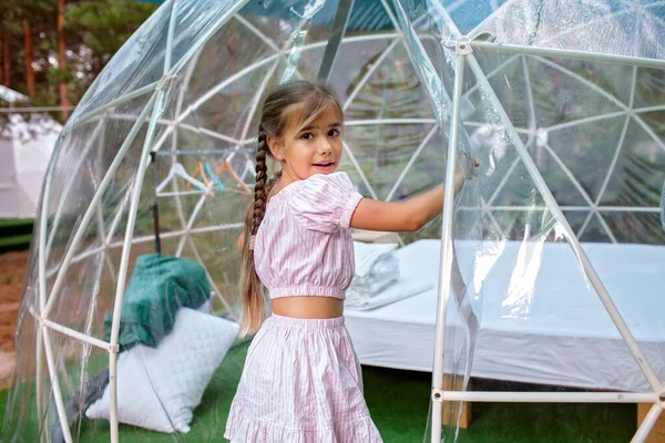 Девушка смотрит через прозрачную палатку колокол в лесу, гламурные, роскошные путешествия, гламурный кемпинг Лицензионные Стоковые Изображения