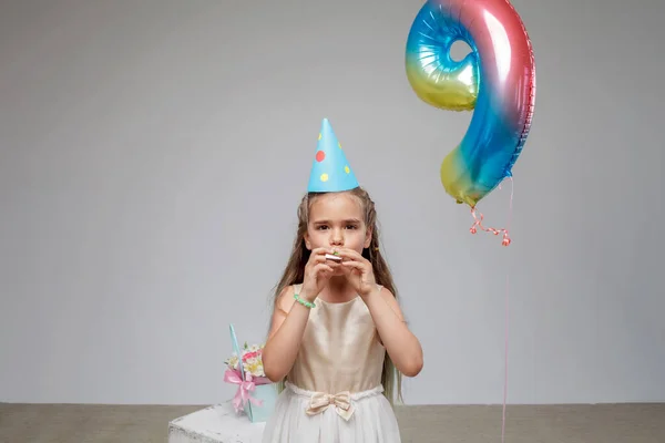 Fille aux cheveux longs en robe de fête, chapeau et accessoires, fond blanc, fête d'anniversaire, studio — Photo