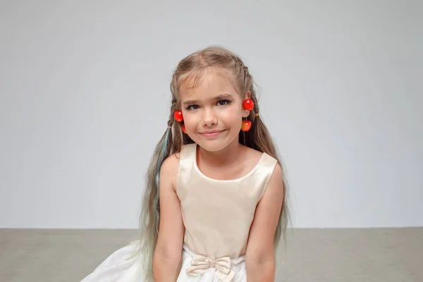 Girl with cherry on ears over white pastel background, birthday celebration, summer fresh look — Stock Photo, Image