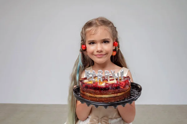 벚꽃을 들고 있는 소녀는 생일 케이크를 촛불 과 흰색 배경, 생일 축하를 들고 있다. — 스톡 사진
