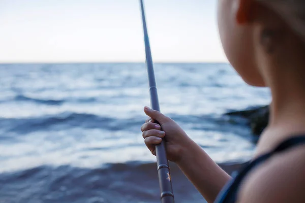 Ragazza in costume da bagno pesca dalla spiaggia di mare al mattino presto, ore blu, weekend attivo, campeggio — Foto Stock