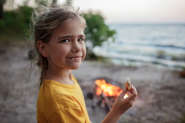 전통적 인 여행용 음식인 캠핑중 불위에서 마시멜로를 굽는 소녀 — 스톡 사진