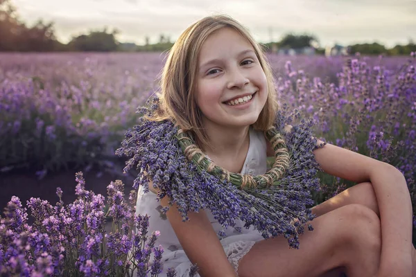 Chica adolescente soñadora con corona floral se sienta en el campo de lavanda. Belleza de la naturaleza, estilo de vida de verano —  Fotos de Stock