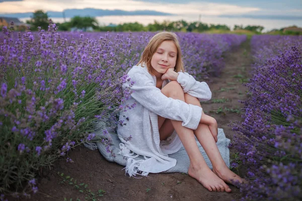 Álmodozó tinédzser lány ül a levendula mezőn. Természet szépsége, nyári életmód, nyugodt táj — Stock Fotó