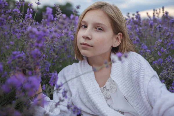Chica adolescente soñadora se sienta en el campo de lavanda. Belleza de la naturaleza, estilo de vida de verano, paisaje tranquilo — Foto de Stock