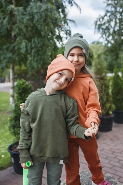 Bambini con cappelli e felpe alla moda che si divertono nel parco, vibrazioni autunnali, stile di bellezza autunnale, moda bambino — Foto Stock