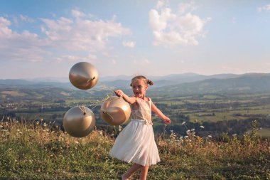 Tecrit üstüne parti. Dağın tepesinde hava balonlarıyla dans eden bir kız, yeni normal.