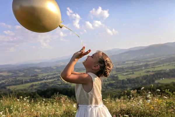 Вечеринка за закрытием. Девушка танцует одна с воздушными шарами на вершине гор, новая нормальная — стоковое фото