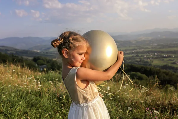 Вечеринка за закрытием. Девушка танцует одна с воздушными шарами на вершине гор, новая нормальная — стоковое фото