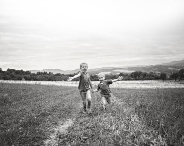 Kardeşiyle birlikte dağlardaki güzel çayırlarda koşan tatlı bir kız.