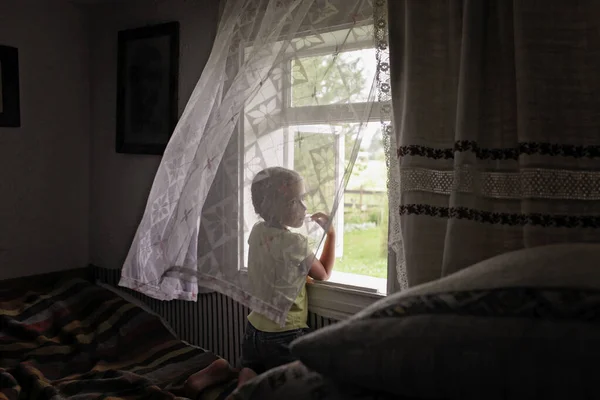 Roztomilé dítě otevírá okno na čerstvý vzduch v časném ránu ve vesnickém domově — Stock fotografie