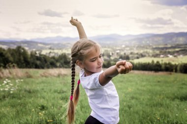 Çekici kız sabahları dağların tepesinde geriniyor ve esniyor.