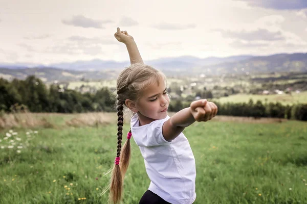 Attractive girl stretching and yawning on the top of the mountains in the morning — Stock Photo, Image