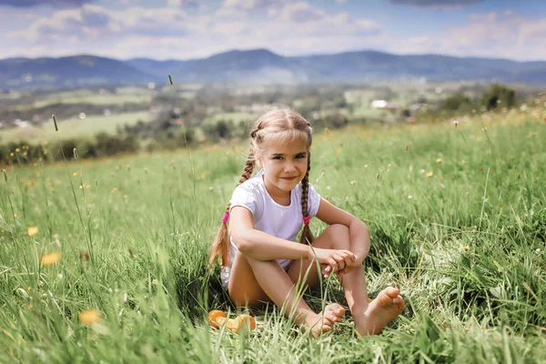 Ragazza rilassante sull'erba verde dopo i suoi esercizi mattutini con manubri in montagna — Foto Stock