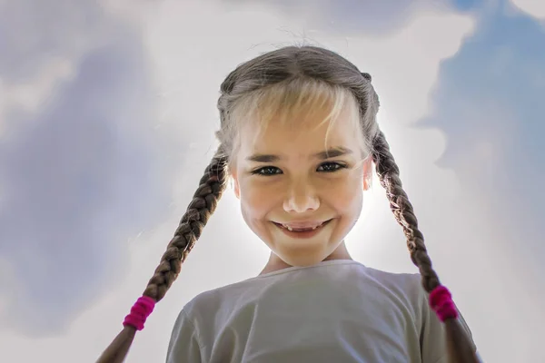 Close-up szczery portret cute girl z dwóch zabawnych warkoczach podjęte na niebie z ziemi — Zdjęcie stockowe