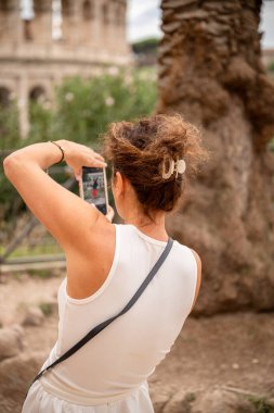 Antik binanın yakınında akıllı telefonuyla fotoğraf çeken bir kadın. Yüksek kalite fotoğraf