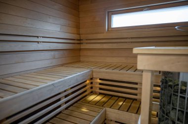 Boş modern ahşap Finlandiya saunası, banklar, sıcak ışıklandırma ve temiz tasarım. Yüksek kalite fotoğraf