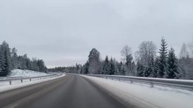 Kış otobanı üzerinde araba sürmek, karlı orman manzarası boyunca kıvrılarak ilerlemek. Yüksek kaliteli FullHD görüntüler