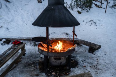 Finlandiya 'nın Laponya' daki karlı kış ormanlarında açık hava ateş çukuru yanıyor. Yüksek kalite fotoğraf