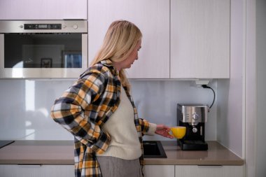 Kadın modern mutfakta ev yapımı espresso makinesiyle kahve hazırlıyor. Yüksek kalite fotoğraf