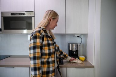 Kadın kahve yaptıktan sonra mutfak tezgahını temizliyor. Yüksek kalite fotoğraf