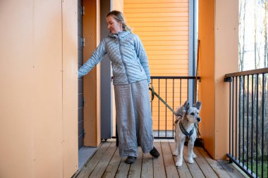 Köpekli bir kadın dışarıda, apartmanın kapısında bekliyor. Yüksek kalite fotoğraf