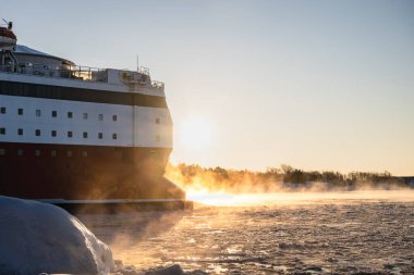 Büyük yolcu feribotu, Kuzey 'in kış mevsiminde gün doğumunda buzlu denizde yol alıyor. Yüksek kalite fotoğraf
