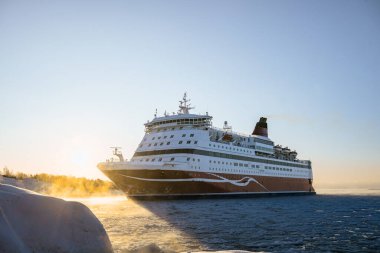 Büyük yolcu feribotu, Kuzey 'in kış mevsiminde gün doğumunda buzlu denizde yol alıyor. Yüksek kalite fotoğraf