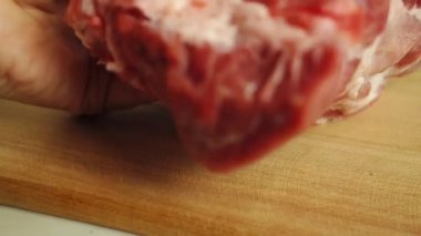 Büyük, sulu bir et parçası ahşap bir tahtanın üzerine yerleştirilir. Yemek yapmaya başla..
